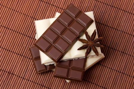 slices of black and white chocolate with anise on dark backgroundの写真素材