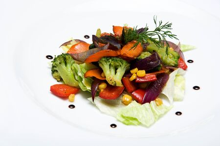Vegetables salad with corn, lettuce, sweet pepper and broccoli on white plateの写真素材