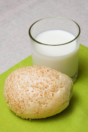Glass of milk with brad roll  on a green backgroundの写真素材
