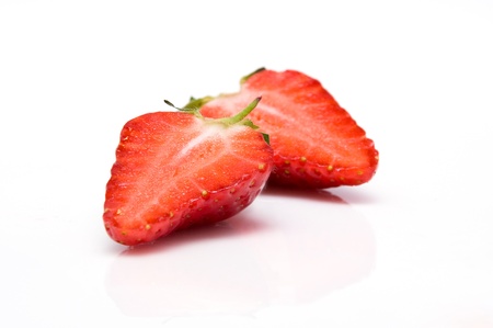 Two half of strawberry isolated on white background with reflectionの写真素材