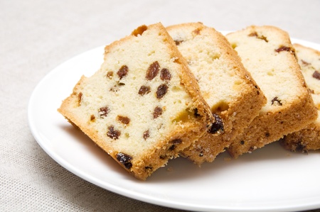 slices of cake with raisins arranged on a white plateの写真素材