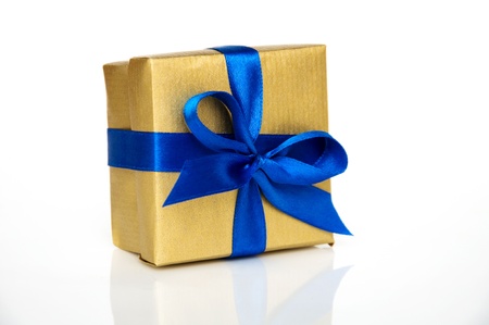 golden gift box with a blue ribbon on a white backgroundの写真素材