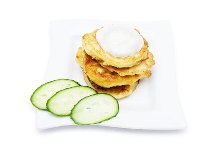 Traditional delicious potato pancakes served with sour cream isolated on white backgroundの写真素材