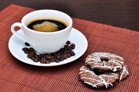 Cup of coffee with cookies and coffee beans on the tableの写真素材