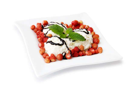 cottage cheese dessert with sour cream, strawberries and chocolate dressing on square plate isolated on a white backgroundの写真素材