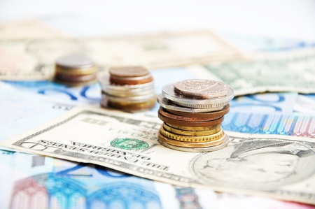 Stacks of mixed coins on background of different countries moneyの写真素材
