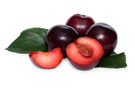 Some plums with two slices of plum over white background