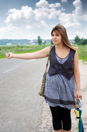 Beautiful young brunette woman hitchhikingの写真素材