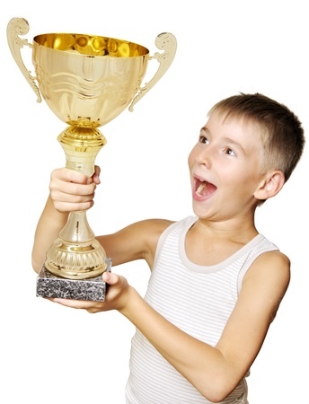 Portrait of an excited little champion with his trophy isolated against white backgroundの写真素材