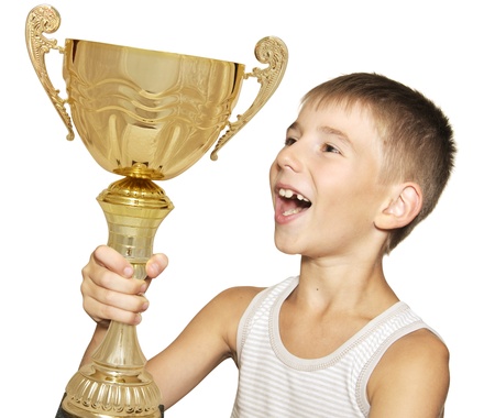 Portrait of an excited little champion with his trophy isolated against white backgroundの写真素材