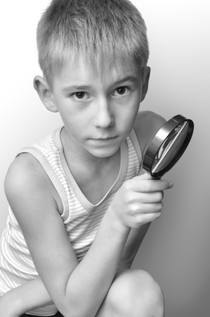 Portrait of serious boy with a magnifying glassの写真素材