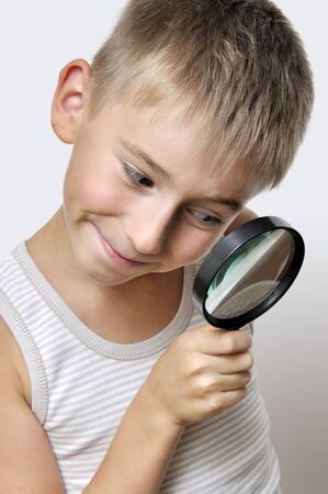 Portrait of smiling boy with a magnifying glassの写真素材