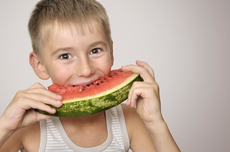 Funny and happy little boy eating watermelonの写真素材