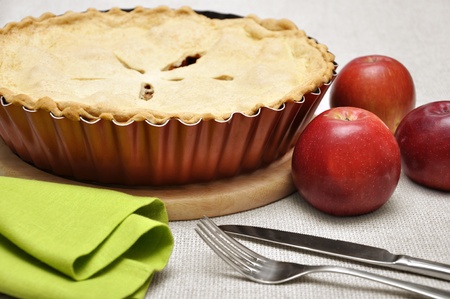 Home-baked apple pie, straight from the oven. Vintage enamel pie plate, fork and knife.の写真素材