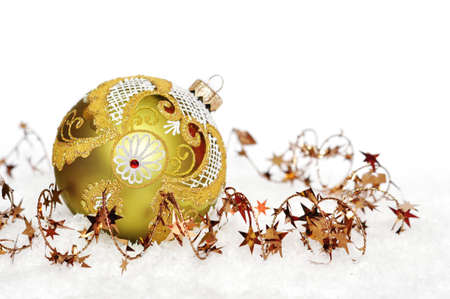 golden christmas ball on the snow over white backgroundの写真素材