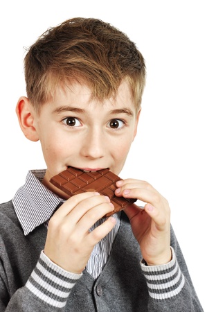 Young Boy Eating A chocolate bar over white backgroundの写真素材