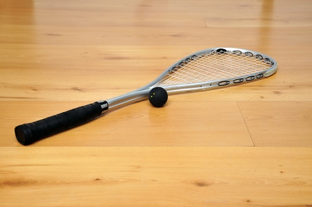 a squash racket and ball on the floorの写真素材