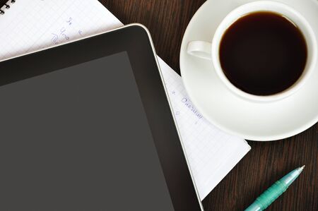 Workplace with  digital tablet, notebook, pen and cup of coffee on work table closeupの写真素材
