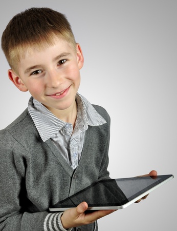 Portrait of a cheerful boy using a tablet computerの写真素材