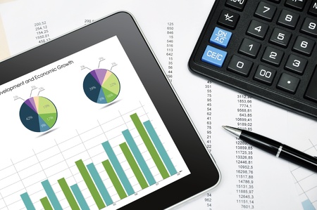 Modern business workplace with digital tablet, calculator, pen and printed data sheetの写真素材
