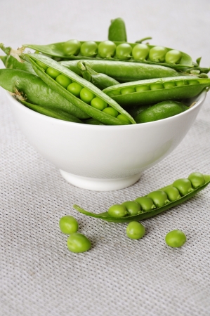 fresh green peas on a white bowl close upの写真素材