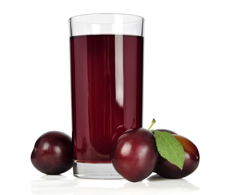 Fresh plums and a glass full of plums juice on a white backgroundの写真素材