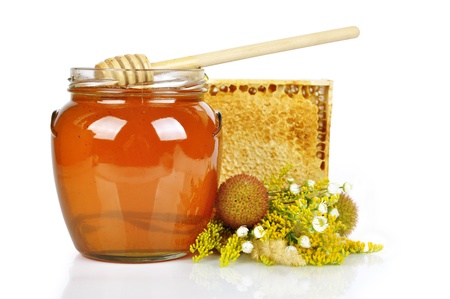 sweet honey in glass jar with wooden honey dripper, fresh honey in comb  and bouquet of wild flowersの写真素材
