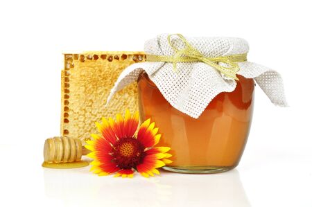 sweet honey in glass jar with wooden honey dripper, fresh honey in comb  and bouquet of wild flowersの写真素材