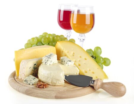 Composition of cheese, grapes, glasses of wine and nuts on a wooden round tray isolated on a white backgroundの写真素材