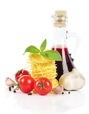Italian pasta, cherry tomatoes, vinegar bottle with  basil and garlic isolated on white backgroundの写真素材