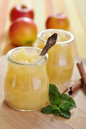 Jar of apple jam with cinnamon and mint on cutting board. Small shallow dof.の写真素材