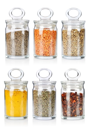 A range of six transparent glass jars of different spices and herbsの写真素材
