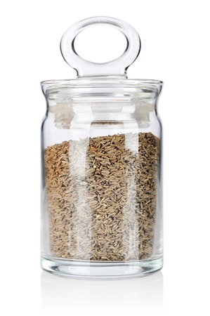 Glass bottle with caraway on white backgroundの写真素材