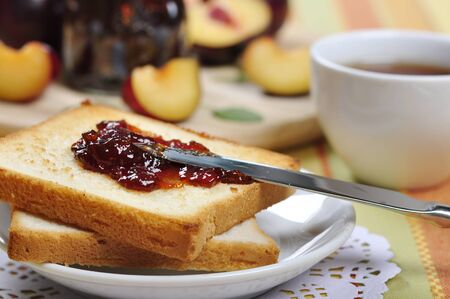 Plum jam with toast on white plate and fresh ripe plums  の写真素材