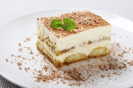 Tiramisu - Classical Dessert with Coffee on white plate  Garnished with Mint の写真素材
