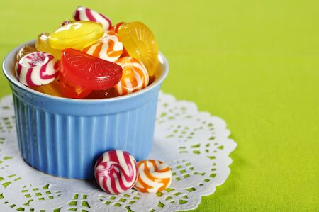 Colorful candy in a blue ceramic bowl closeupの写真素材