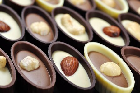 Assorted chocolate candies with different nuts, closeupの写真素材