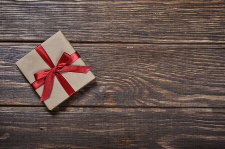Gift box with red ribbon over wooden backgroundの写真素材