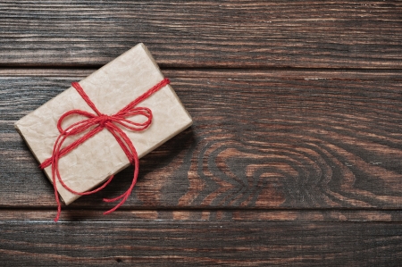 Vintage gift box with red ribbon on wooden backgroundの写真素材