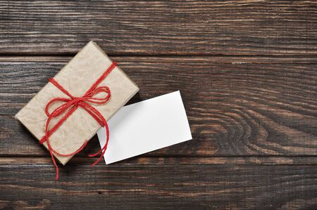 Vintage gift box with blank gift tag on old wooden background の写真素材