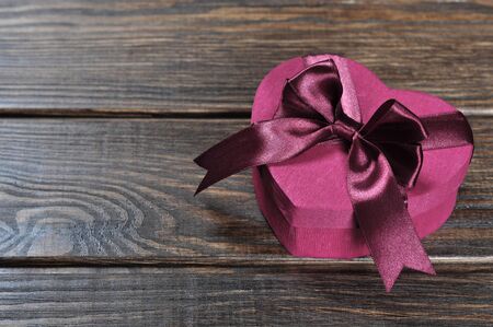 Heart shaped pink Valentines Day gift box on wooden background  の写真素材
