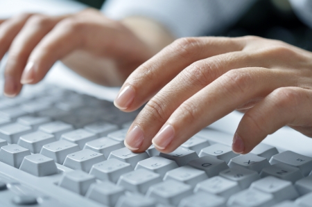 Close-up of typing female hands on white keyboardの写真素材