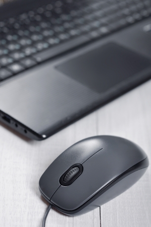 Laptop with computer mouse on the table closeupの写真素材