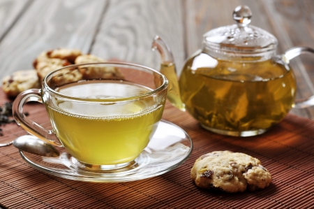 green tea  in cup and teapot with cookies on wooden backgroundの写真素材