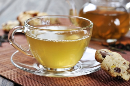 green tea  in cup and teapot with cookies on wooden backgroundの写真素材
