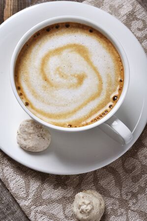 Cup of coffee with almond biscotti over wooden backgroundの写真素材