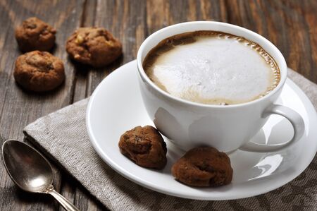 Cup of coffee with cookies over wooden backgroundの写真素材