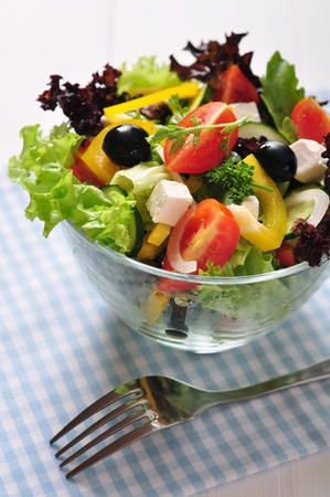 Greek salad in glass bowl on wooden background closeupの写真素材