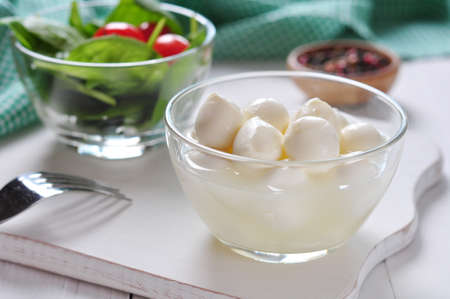 Mozzarella, tomatoes, basil on white wooden backgroundの写真素材