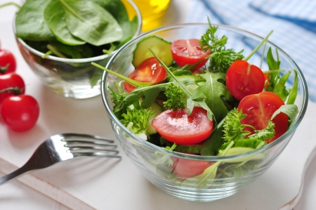 fresh salad with tomatoes cherry, arugula and cucumber in glass bowlの写真素材